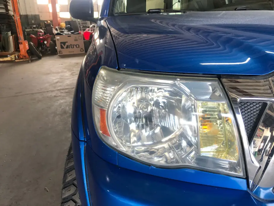 Restored clear headlight on a blue Toyota Tacoma