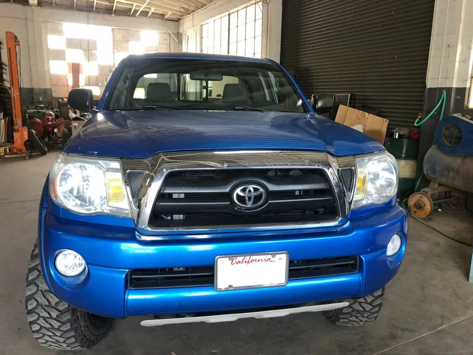 Blue Toyota Tacoma in the shop bay with restored headlights
